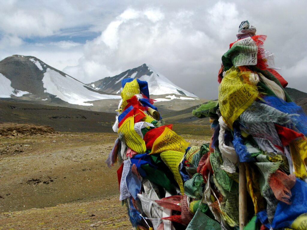 Banderas de oración desgastadas por el viento en lo alto de un collado rocoso