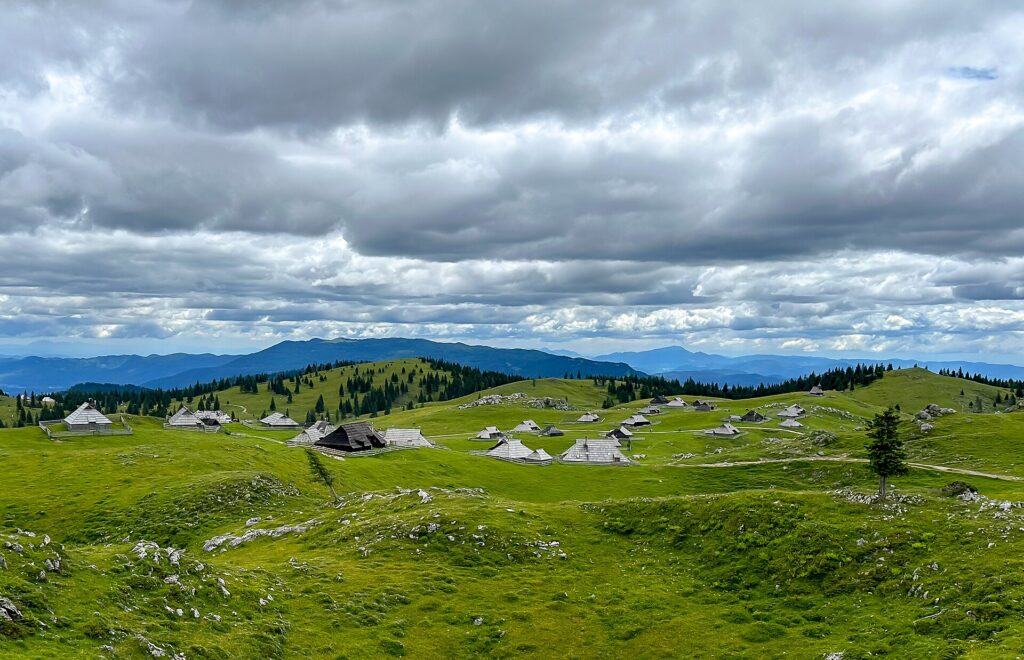 Casas de piedra y madera en un pueblo alpino con las laderas ya doradas