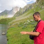 Guía encordado avanza por un glaciar con dos clientes detrás sobre nieve dura