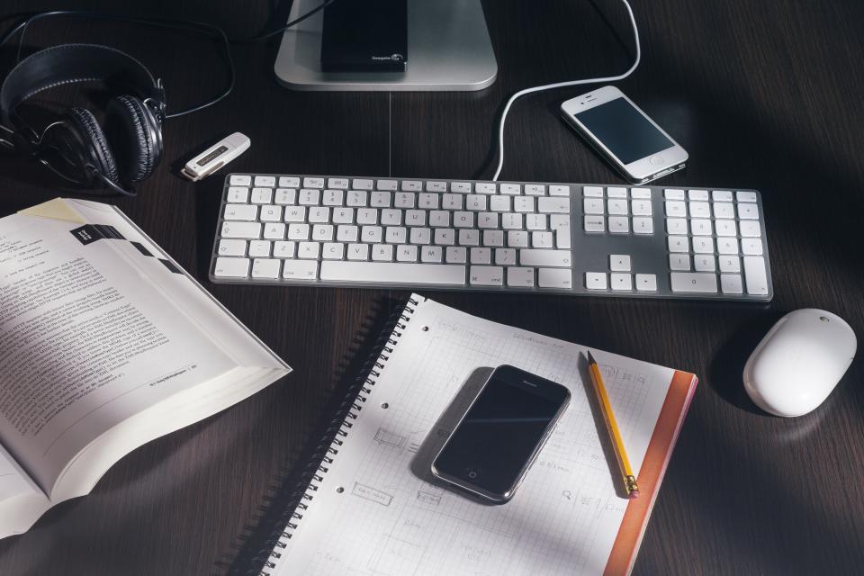 Cuaderno abierto con anotaciones y una calculadora sobre una mesa de madera