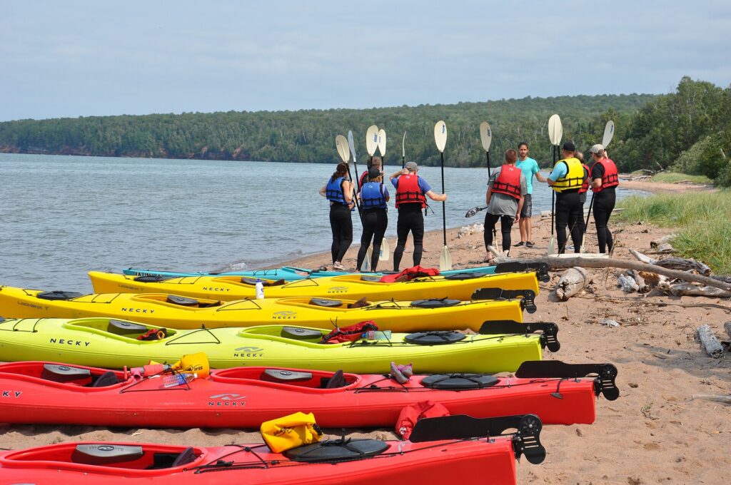 Dos kayaks de mar pegados costado con costado mientras un palista sujeta la bañera del otro