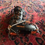 Crampones de acero montados sobre botas rígidas clavados en una ladera de nieve dura
