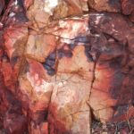 Alojamiento bajo de madera frente a una laguna con cumbres de granito al fondo